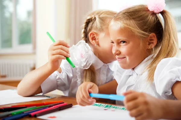 Två små flickor gossip i klassrummet — Stockfoto