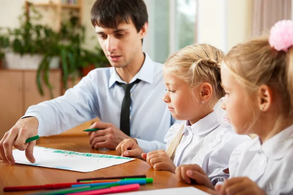 Teacher helping students with schoolwork in school classroom. Ho — Stock Photo, Image