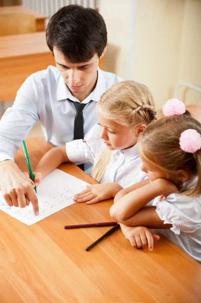Teacher helping elementary school pupils with their tasks — Stock Photo, Image