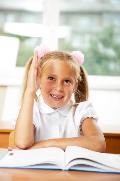 Ritratto di una giovane ragazza a scuola alla scrivania . — Foto Stock