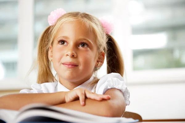 Retrato de una niña en la escuela en el escritorio . —  Fotos de Stock