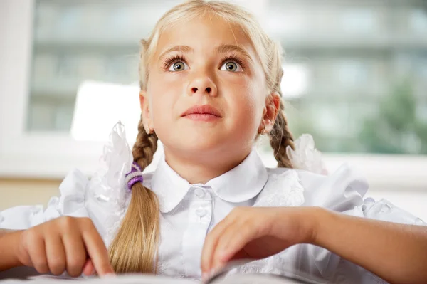Ritratto di una giovane ragazza a scuola alla scrivania . — Foto Stock