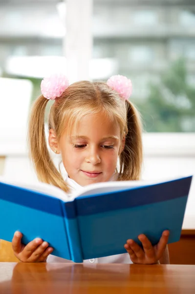 Afbeelding van slimme kind lezen van interessante boek in klas — Stockfoto