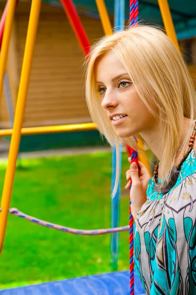 Portret van vrij jonge vrouw swingen op speelplaats in het park een — Stockfoto