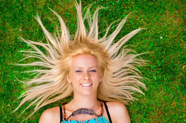 彼の周りの太陽のように若い女性の髪と緑の芝生の上に敷設 — ストック写真