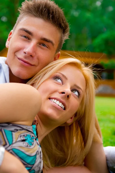 Porträtt av vackra unga paret sitter på marken i parken rel — Stockfoto
