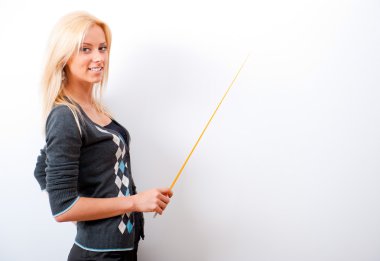 Portrait of young teacher pointing on white marker board in mode clipart