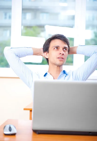 A young man sitting in front of a laptop in his office — Stock Photo, Image