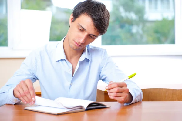 Empresário sentado dentro de casa e escrevendo plano em seu diário — Fotografia de Stock