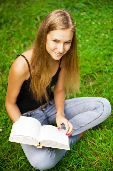 Vacker kvinnlig student utomhus med en bok på campus park — Stockfoto