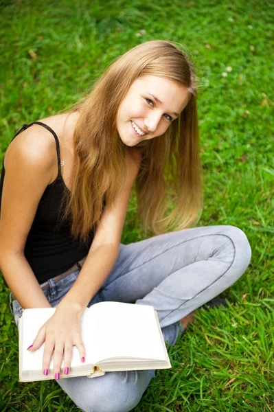 Hermosa estudiante al aire libre con un libro en el parque del campus — Foto de Stock