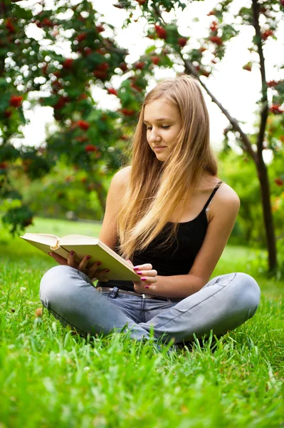 Beautiful female student outdoors with a book at campus park — Stock Photo, Image