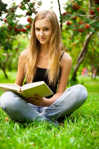 Beautiful female student outdoors with a book at campus park — Stock Photo, Image