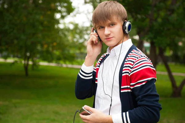 Student listening language course in headphones outside school — Stock Photo, Image
