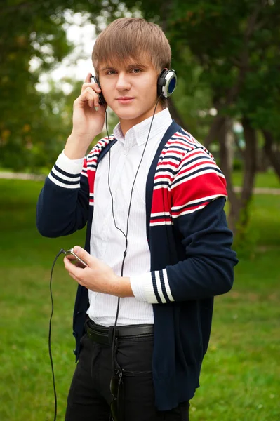 Estudiante escuchando curso de idiomas en auriculares fuera de la escuela — Foto de Stock