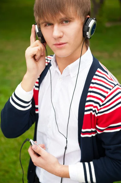 Student luisteren taalcursus in hoofdtelefoon buiten de school — Stockfoto
