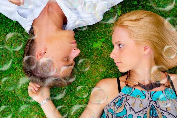 A portrait of a sweet couple in love with soap bubbles around. P — Stock Photo, Image