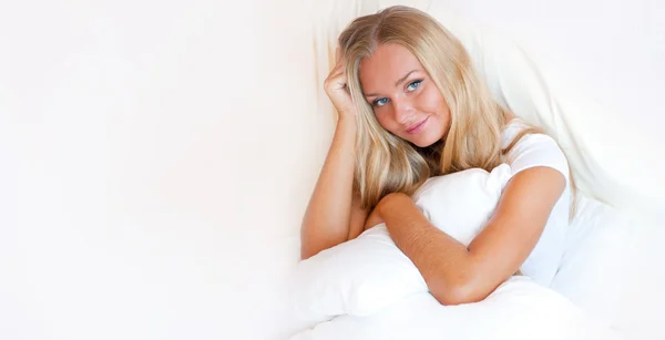 Portrét mladé ženy relaxující na posteli — Stock fotografie