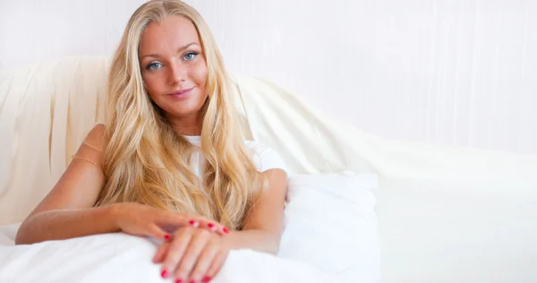 Portret van jonge vrouw ontspannen op bed — Stockfoto