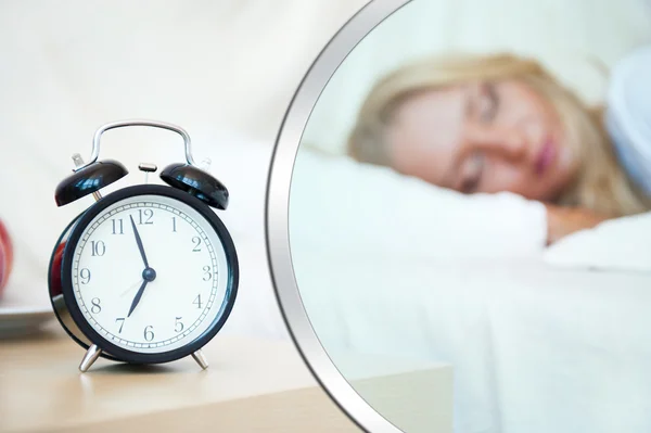 Kvinna som sover i sängen och väckarklocka — Stockfoto