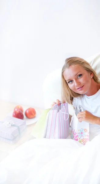 Joven chica atractiva feliz desempacar bolsas de compras en el dormitorio o h —  Fotos de Stock