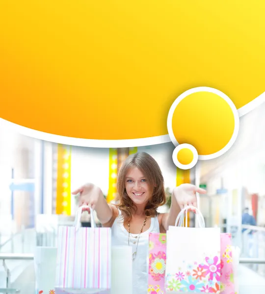 Mujer de compras con un montón de bolsas sonríe dentro del centro comercial. Ella es feliz. — Foto de Stock