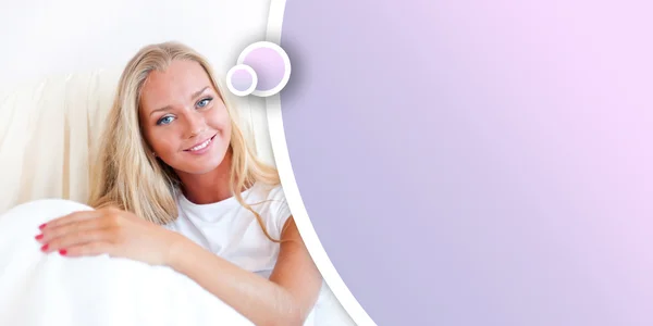 Ung blond kvinna njuter en solig morgon i sängen — Stockfoto