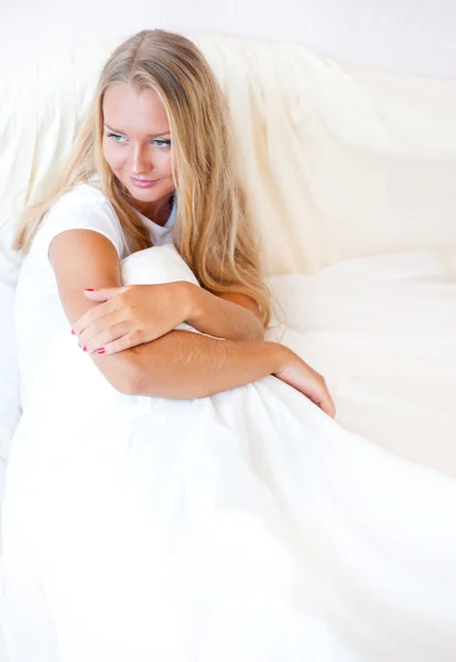 Jeune femme blonde profitant d'une matinée ensoleillée au lit — Photo