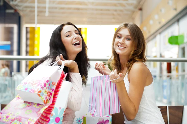 Two excited shopping woman together inside shopping mall. Horizo Stock Photo