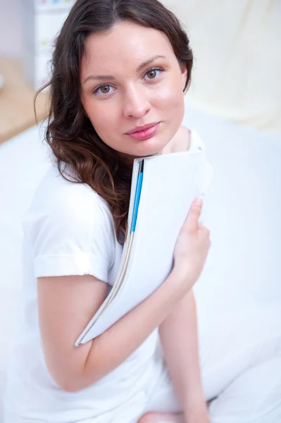 Mujer joven con un cuaderno de estudio en casa sentado relajado en —  Fotos de Stock