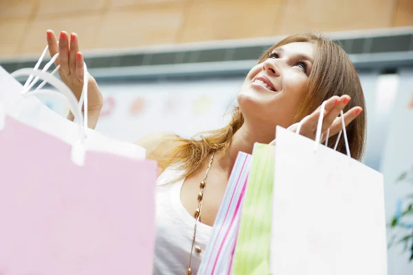 Foto de la joven mujer alegre con bolsas de compras en el fondo —  Fotos de Stock