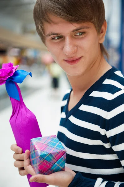 Portret młodego człowieka wewnątrz centrum handlowego stałego zrelaksowany i — Zdjęcie stockowe