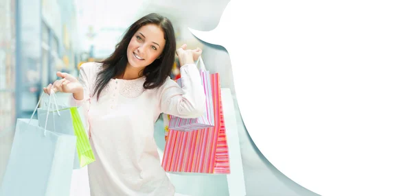 Photo of young joyful woman with shopping bags on the background — Stock Photo, Image
