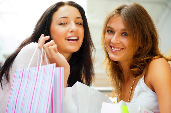 Duas mulheres de compras animadas juntas dentro do shopping. Horizontes — Fotografia de Stock