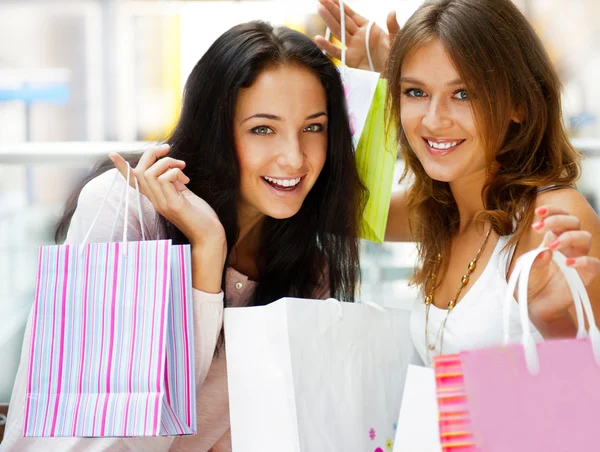 Due eccitati donna dello shopping che riposa sulla panchina al centro commerciale loo — Foto Stock