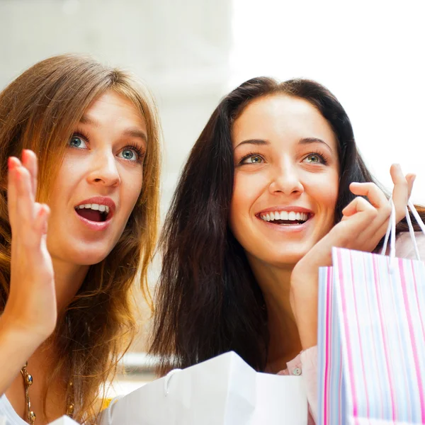 Dos mujeres de compras emocionadas juntas dentro del centro comercial. Horizo —  Fotos de Stock