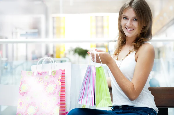 Счастливая покупательница с сумками и улыбкой. Она ходит по магазинам. — стоковое фото
