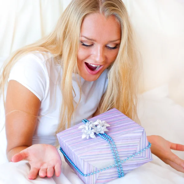 Yatak odası sürpriz hediyesi - mutlu kadın yatak odasında — Stok fotoğraf