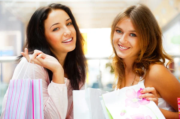 Duas mulheres de compras animadas juntas dentro do shopping. Horizontes — Fotografia de Stock