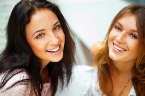 Due donne sussurrano e sorridono mentre fanno shopping all'interno del centro commerciale — Foto Stock