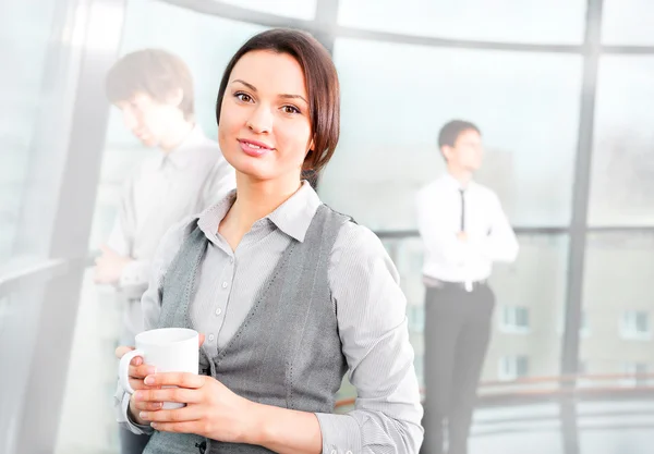 Portrait of a cute business woman with colleagues at the backgro — Stock Photo, Image