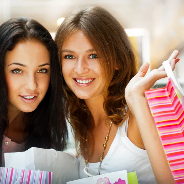 Dwa podekscytowany zakupy kobieta na ławce w centrum handlowego loo — Zdjęcie stockowe