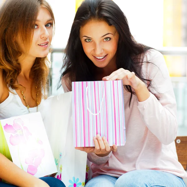 Dwa podekscytowany zakupy kobieta na ławce w centrum handlowego loo — Zdjęcie stockowe