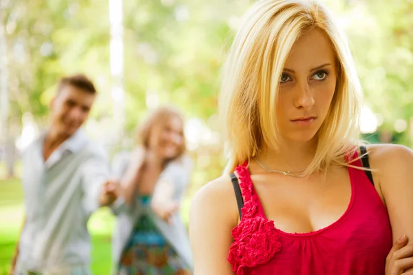 Menina adolescente perturbado sendo zombado pelo grupo do outro jovem pio — Fotografia de Stock