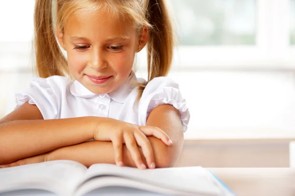 Afbeelding van slimme kind lezen van interessante boek in klas — Stok fotoğraf