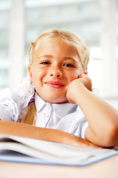 Retrato de una niña en la escuela en el escritorio . — Foto de Stock