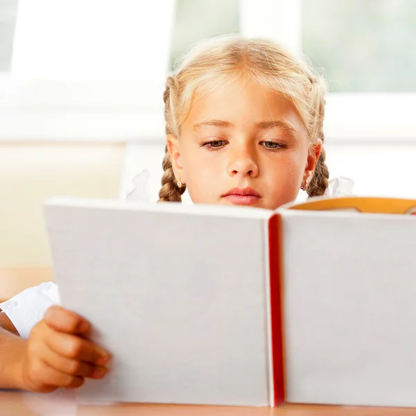 Afbeelding van slimme kind lezen van interessante boek in de klas. Hori — Stockfoto