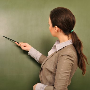 Portrait of young woman teacher standing near blackboard and exp clipart