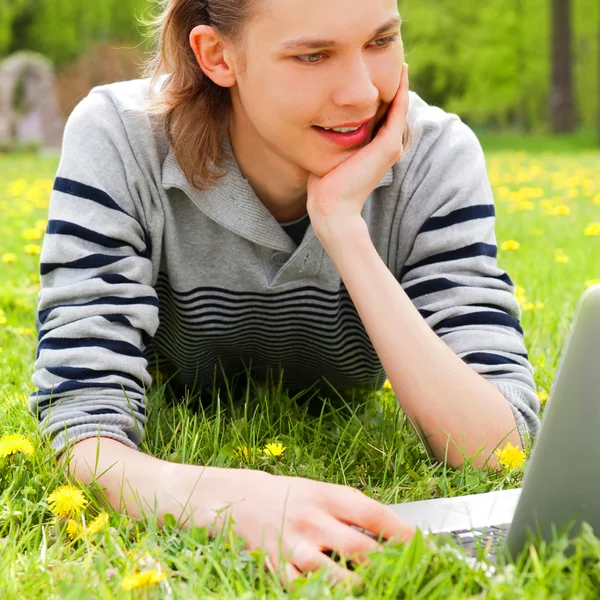 Un homme souriant avec ordinateur portable en plein air — Photo