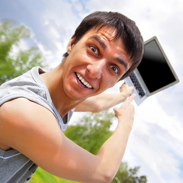 Casual young man pointing at laptop screen — Stock Photo, Image